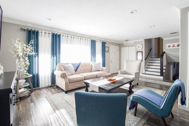 modern furnished living room with blue chairs and white couch