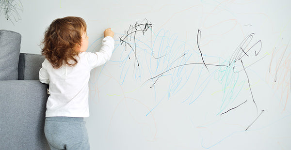 child drawing on wall